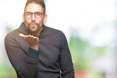 Bir öpücük el ile güzel ve seksi olmak hava üfleme kamera bakarak izole arka plan üzerinde gözlük takan yakışıklı delikanlı. Aşk ifade.