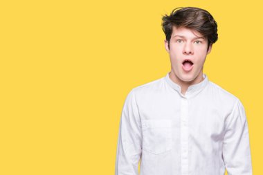 Genç yakışıklı iş adamı izole arka plan korkuyor ve şok sürpriz ifade, korku ve heyecan yüz üzerinden.