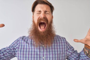 Redhead İrlandalı adam izole beyaz arka plan üzerinde kablosuz kulaklık kullanarak müzik dinlerken silah kaldırdı ve kapalı gözleri heyecan çığlık ile başarı için deli ve deli kutluyor. Kazanan kavramı