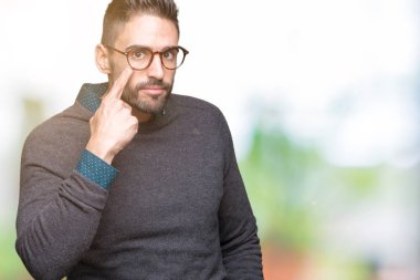 Genç yakışıklı adam gözlük izole üzerinde arka plan işaret jest göz izlemek için şüpheli ifade