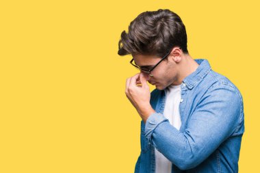 Genç yakışıklı adam izole arka plan yorgun sürtünme burun ve göz yorgunluğu ve baş ağrısı duygu üzerinde güneş gözlüğü takıyor. Stres ve hayal kırıklığı kavramı.