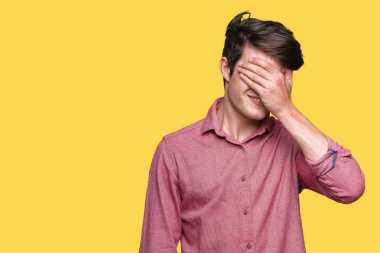 Genç yakışıklı iş adamı gülümsüyor ve gözleri için sürpriz kapsayan yüz el ile gülüyor izole arka plan üzerinde. Kör kavramı.