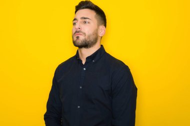 Genç yakışıklı adam possing ve modelleme sarı izole bac üzerinde