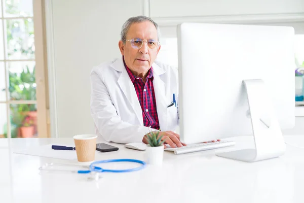 Senior doctor man at the clinic concentrated working with comput — Stock Photo, Image