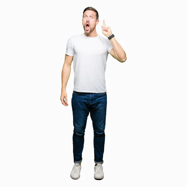 Hombre Guapo Con Camiseta Blanca Casual Apuntando Con Dedo Hacia —  Fotos de Stock