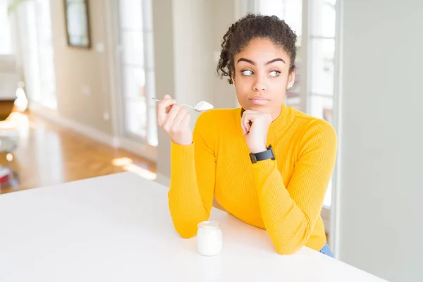 Young African American Woman Eating Healthy Natural Yogurt Serious Face — Stock Photo, Image