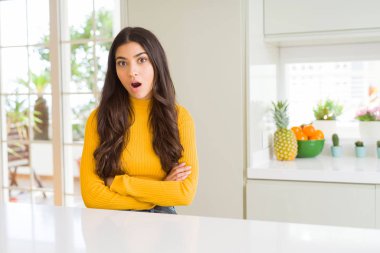 Genç güzel kadın evde beyaz tablo korkuyor ve sürpriz ifade, korku ve heyecan yüz ile şok.