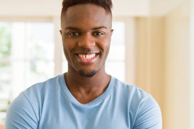 Gülümseyen yüzünde kocaman bir gülümseme ile neşeli Afrika yakışıklı genç