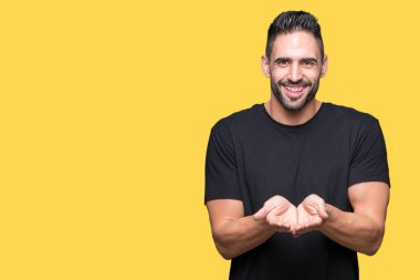 Yakışıklı delikanlı izole arka plan üzerinde gülen ellerle birlikte alma veya jest vererek palms. Ayrı tutma ve koruma