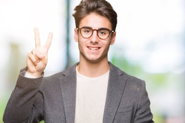 Gösterilen arka plan üzerinde gözlük takan genç iş adamı izole ve parmakları ile işaret kendinden emin ve mutlu gülümseyerek ise ikinci.