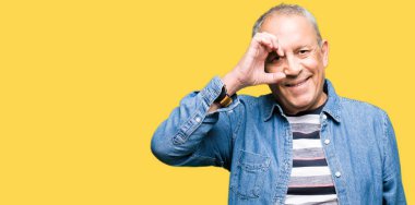 Gülümseyen, parmakları ile mutlu yüz üzerinden seyir göz el ile ok jest yapıyor Kot ceket giymiş yakışıklı komuta sizde.