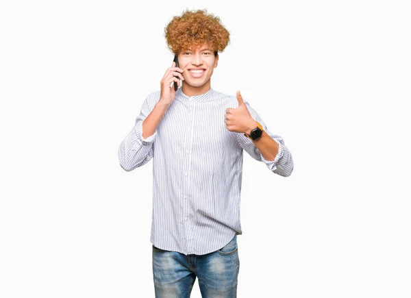 年轻英俊的男人在电话里高兴地笑着做着确定的标志 用手指竖起大拇指 优秀的标志 — 图库照片