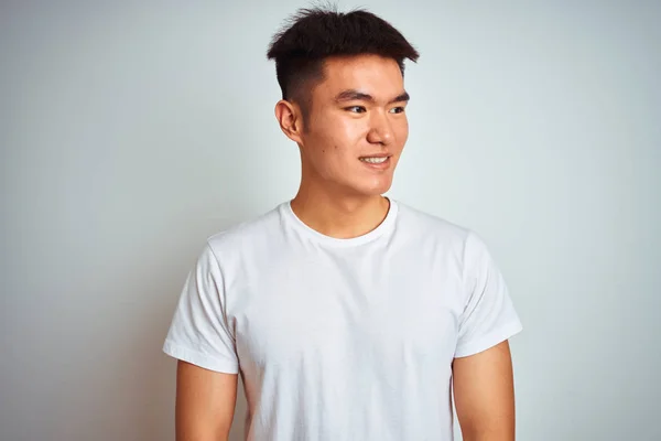 孤立した白い背景の上に立つTシャツを着たアジアの若い中国人男性は 笑顔で横を向き 自然な表情 自信を持って笑う — ストック写真