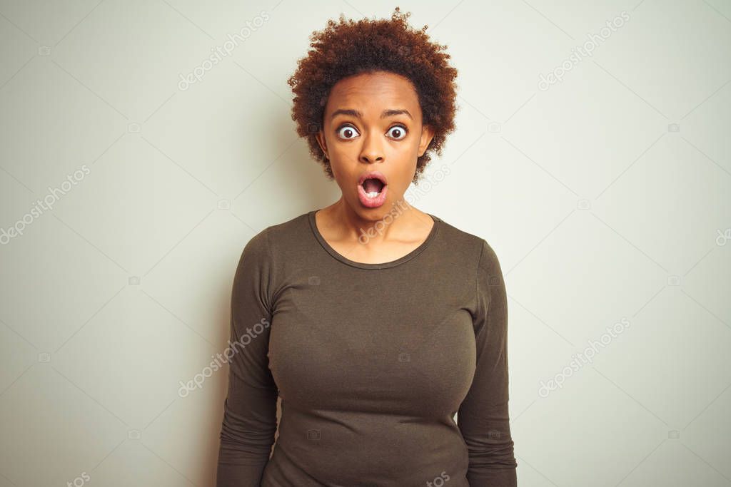 Young beautiful african american woman with afro hair over isolated background afraid and shocked with surprise expression, fear and excited face.