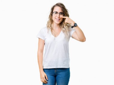 Güzel genç sarışın kadın izole arka plan üzerinde gözlük takan yüz ve burun el parmağı ile işaret, neşeli gülümseyen