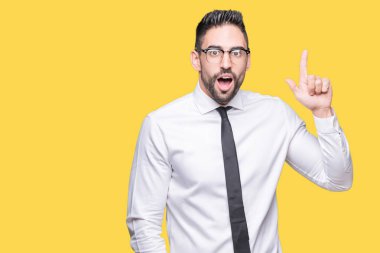 Başarılı fikirle izole arka plan işaret parmağı üzerinde gözlük takan genç yakışıklı iş adamı. Çıktıktan ve mutlu. Bir numara.