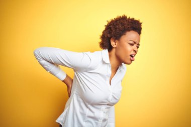 Izole sarı arka plan üzerinde Afrikalı-Amerikalı iş kadını sırt ağrısı Acı, el ile geri dokunmadan, kas ağrısı