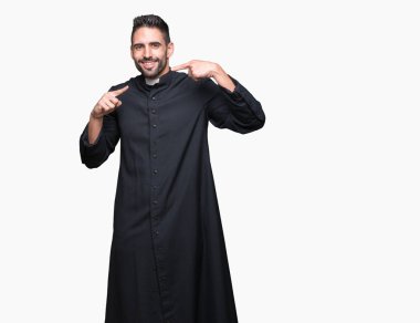 Genç Hıristiyan rahip emin gösterilen ve işaret parmakları diş ve ağız ile gülümseyen izole arka plan üzerinde. Sağlık kavramı.