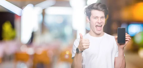 Mladý Muž Ukazuje Displej Smartphonu Izolované Pozadí Šťastný Velkým Úsměvem — Stock fotografie