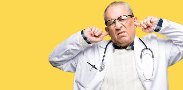 Przystojny Doktor Starszy Człowiek Sobie Płaszcz Medycznych Obejmujących Uszy Palcami — Zdjęcie stockowe