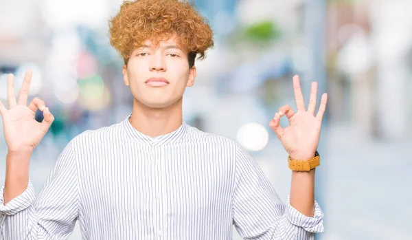 Şık gömlek giymiş afro saçlı Genç yakışıklı iş adam sakin ol ve gülümseyen gözlerle kapalı parmak jestle meditasyon yapıyor. Yoga kavramı.