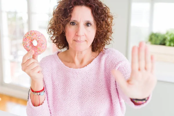 Senior Vrouw Eten Roze Suiker Donut Met Open Hand Doen — Stockfoto