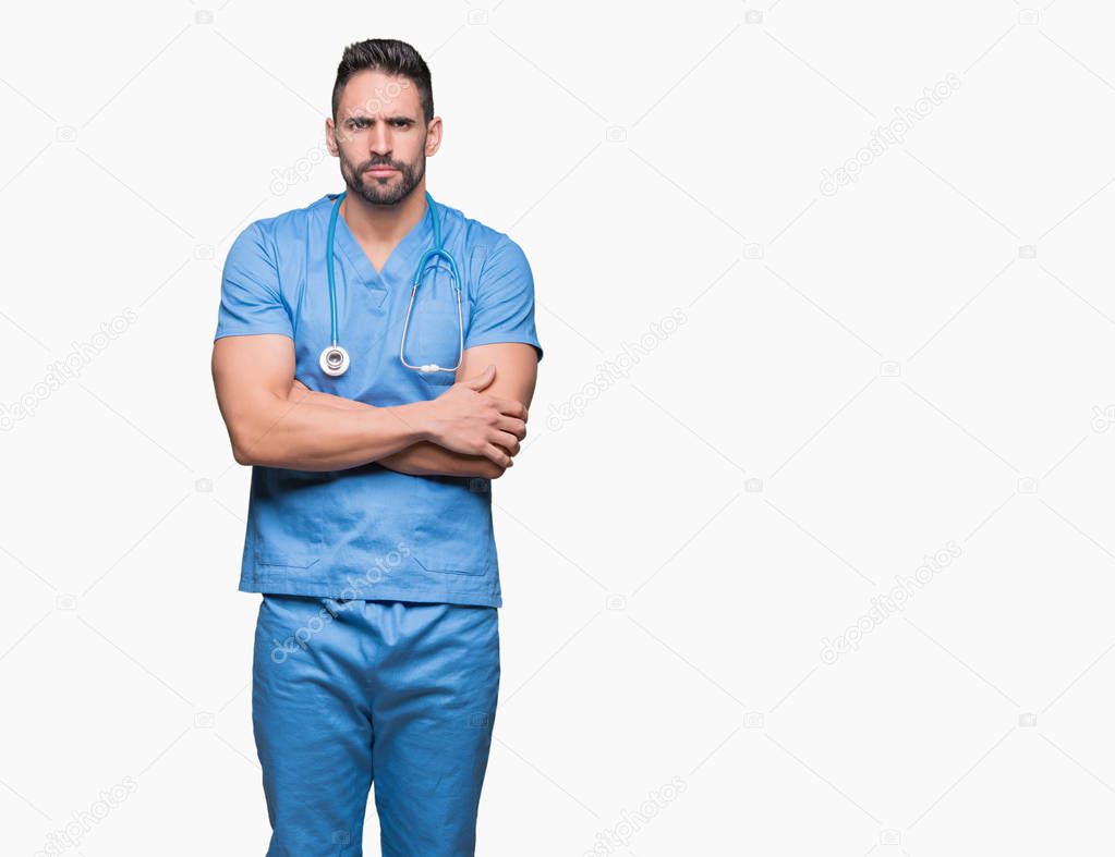 Handsome young doctor surgeon man over isolated background skeptic and nervous, disapproving expression on face with crossed arms. Negative person.