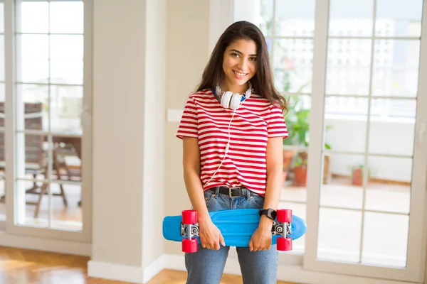 Mulher skatista bonita sorrindo amigável de pé com skate — Fotografia de Stock