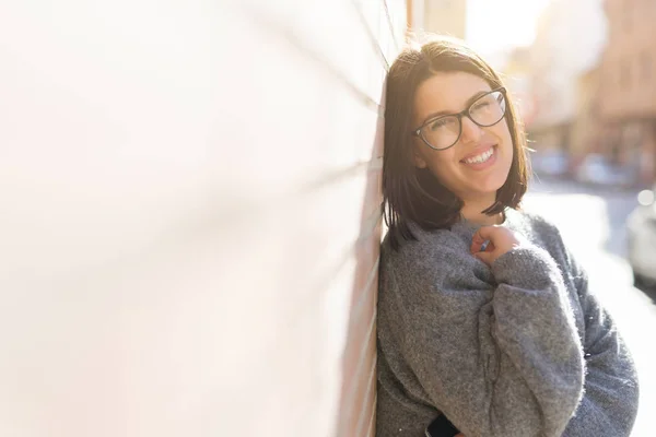 Belle jeune femme portant des lunettes souriant gai penché o — Photo