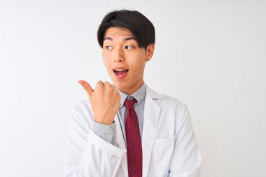 Izole beyaz arka plan üzerinde duran kravat ve ceket giyen Çinli bilim adamı mutlu yüz görünümlü ve başparmak ile yan işaret gülümseyerek.