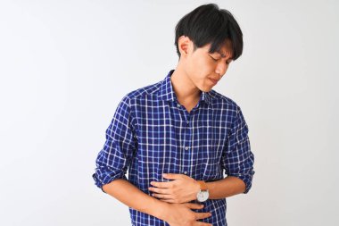 Rahat mavi gömlek giyen genç çinli adam mide üzerinde el ile izole beyaz arka plan üzerinde duran mide, ağrılı hastalık kötü hissediyorum. Ağrı kavramı.