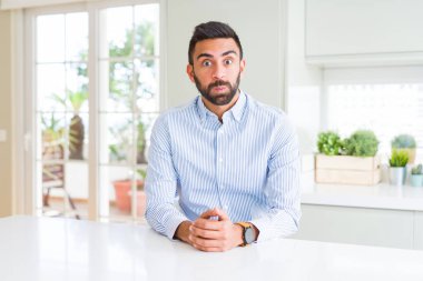 Yakışıklı İspanyol iş adamı komik yüzü ile yanakları şişirme. Ağız hava ile şişirilmiş, deli ifade.