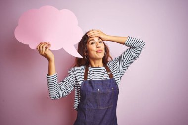 Izole pembe arka plan üzerinde bulut konuşma balonu tutan önlük giyen güzel şef kadın baş el ile vurguladı, utanç ve sürpriz yüz ile şok, kızgın ve sinirli. Korku ve hata için üzgün.