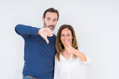Güzel orta yaş kaç aşk yaparken yukarı ve aşağı başparmak izole arka plan, anlaşmazlık ve anlaşma ifade içinde. Deli çatışma