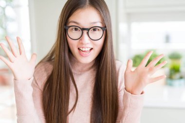 Güzel Asyalı kadın deli ve silah ile başarı için hayran kutluyor gözlük takan kaldırdı ve açık gözleri çığlık heyecanlı. Kazanan kavramı