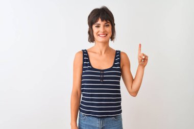 Genç güzel kadın çizgili t-shirt izole beyaz arka plan üzerinde duran gösteren ve kendinden emin ve mutlu gülümserken parmak sayısı bir işaret giyen.