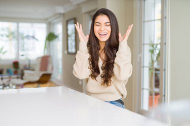 Genç güzel kadın evde deli ve çığlık kaldırdı ve kapalı gözleri heyecanlı silah ile başarı için deli kutluyor. Kazanan kavramı