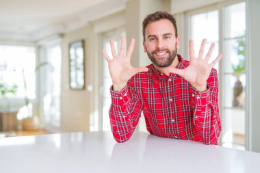 Renkli gömlek giyen yakışıklı adam gösteren ve parmakları ile işaret on numara emin ve mutlu gülümserken.