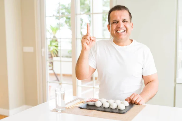 Homem Meia Idade Comendo Bolinhos Asiáticos Casa Apontando Dedo Para — Fotografia de Stock