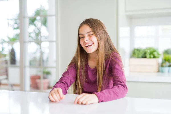 Schöne Junge Mädchen Kind Auf Weißem Tisch Zwinkert Die Kamera — Stockfoto