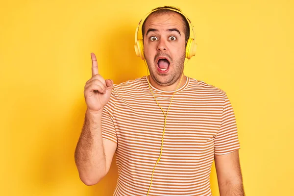 Joven Escuchando Música Usando Auriculares Parados Sobre Fondo Amarillo Aislado — Foto de Stock