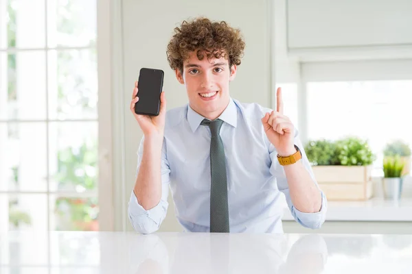 Mladý Obchodní Muž Který Kanceláři Zobrazuje Telefon Smartphone Překvapen Myšlenkou — Stock fotografie