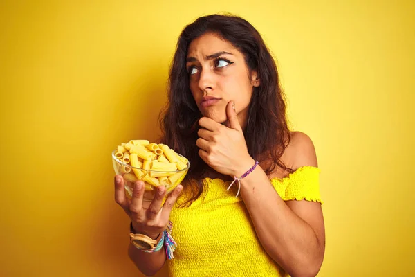 Young Beautiful Woman Holding Bowl Dry Macaroni Pasta Isolated Yellow — Stock Photo, Image