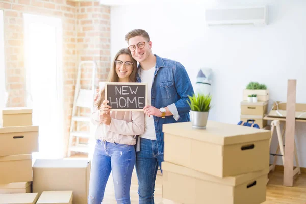 Schönes junges Paar, das sich verliebt umarmt und die Tafel hält — Stockfoto