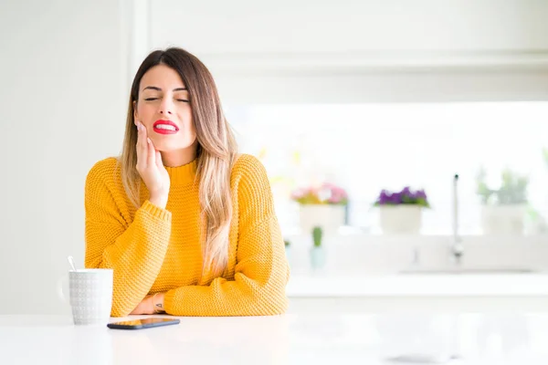歯痛や歯の病気で痛みを伴う表情で口に触れる自宅でコーヒーを飲む若い美しい女性 歯科医の概念 — ストック写真