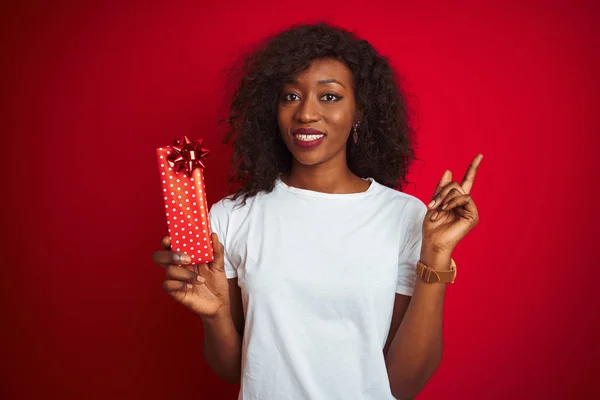 Молодая Африканская Американка Держит Валентинку Подарок Стоя Изолированном Красном Фоне — стоковое фото