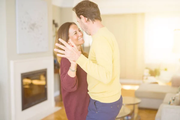 Romantic middle age couple dancing together in love at home