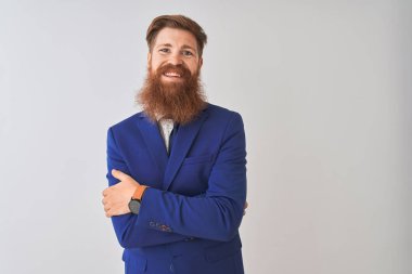 Genç kızıl saçlı İrlandalı işadamı izole beyaz arka plan üzerinde duran takım elbise giyen mutlu yüz kameraya bakarak çapraz kolları ile gülümseyerek. Pozitif kişi.