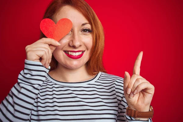 Joven Pelirroja Romántica Mujer Sosteniendo Corazón Sobre Fondo Rojo Aislado — Foto de Stock