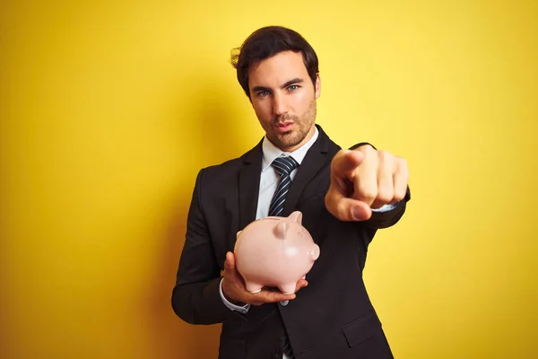 Young Handsome Businessman Holding Piggy Bank Isolated Yellow Background Pointing — Stock Photo, Image